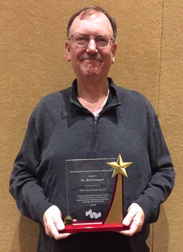 Dr. Bob Glasgow displays the Leroy Sachs Award for lifetime achievement.
