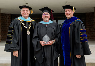 SBU kinesiology chair Joe Wooderson (center) is honored by SBU President Dr. Eric A. Turner (left) and Provost Dr. Lee Skinkle.