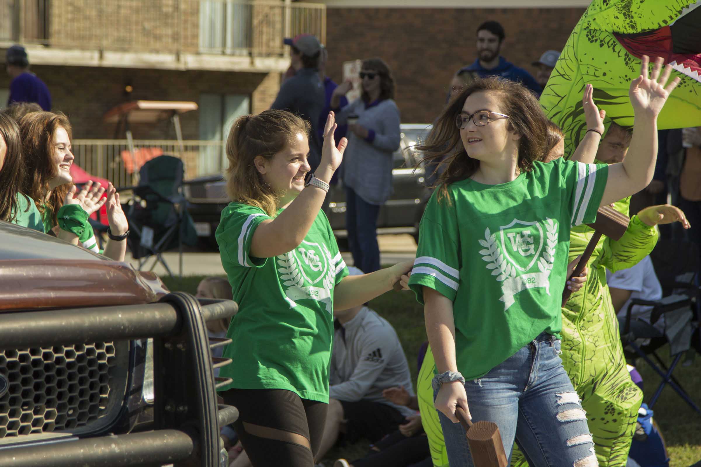 girls waving while walking in parade