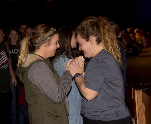 Katelyn Brantingham and Tali Rose pray during the commissioning service.