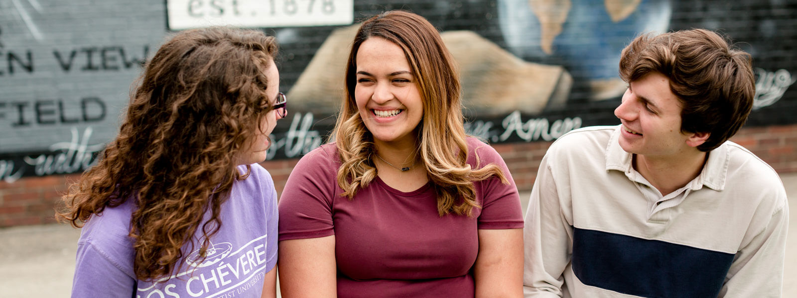 professor chats with students at table in Sports Cafe