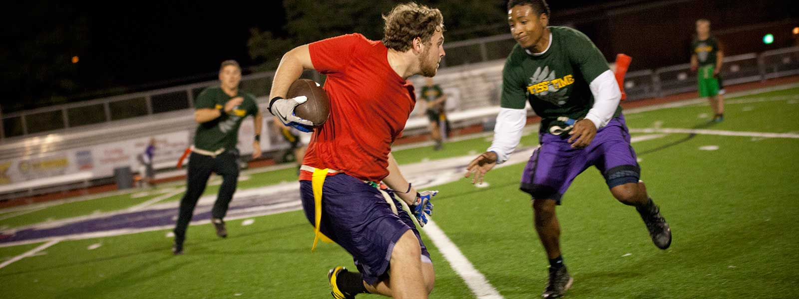 students playing flag football at night