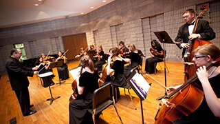 strings ensemble rehearses on stage