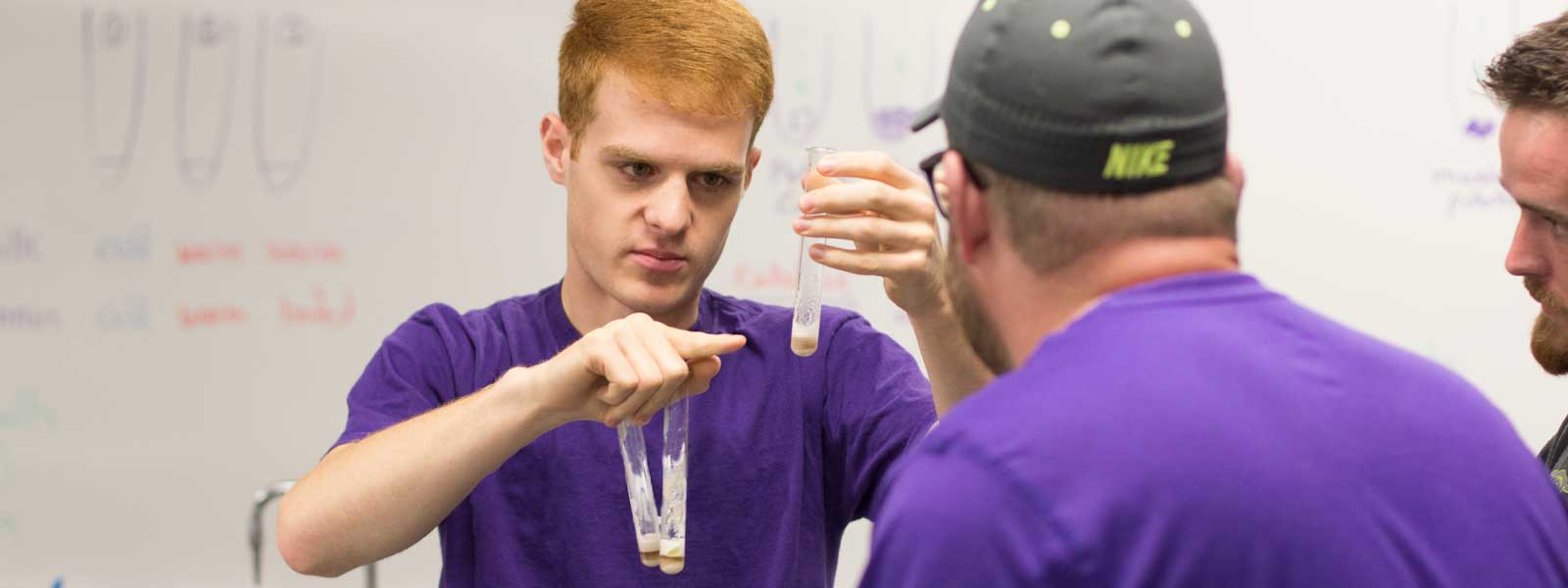 group of students concentrate on chemistry experiment