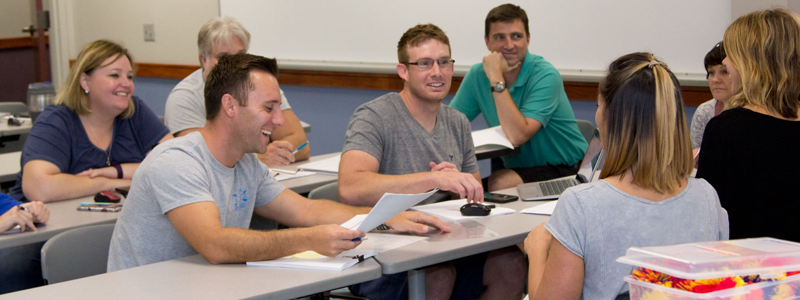students smiling and laughing while participating in class group discussion