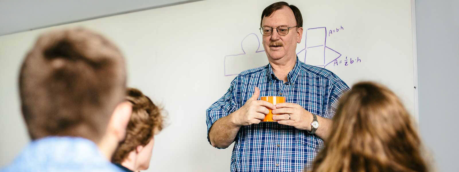 math professor giving lecture holding diagram as example