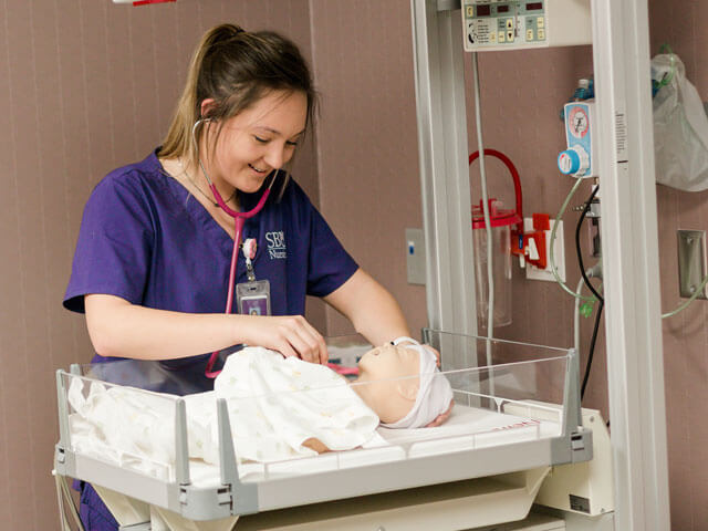 nursing student practices with mannequin