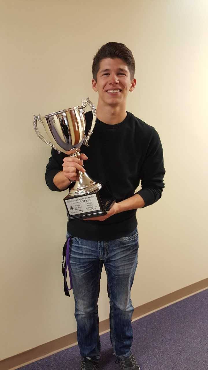 Jordan Martin poses with one of the Speaking Bearcats' trophies.
